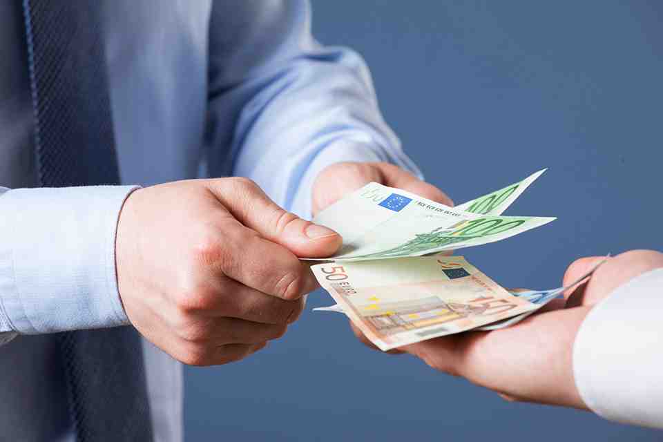 © zest_marina - stock.adobe.com zwei Hände übergeben Geldscheine in eine dritte Hand