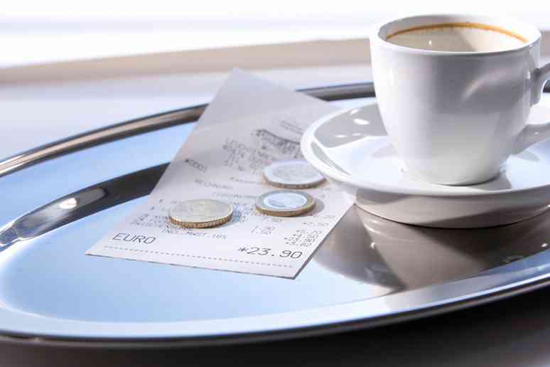 © 0pidanus - stock.adobe.com Trinkgeld auf Tablett mit leerer Kaffeetasse