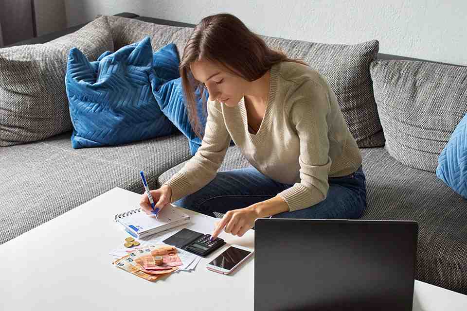 © Lukasz - stock.adobe.com Frau mit Taschenrechner und Bargeld