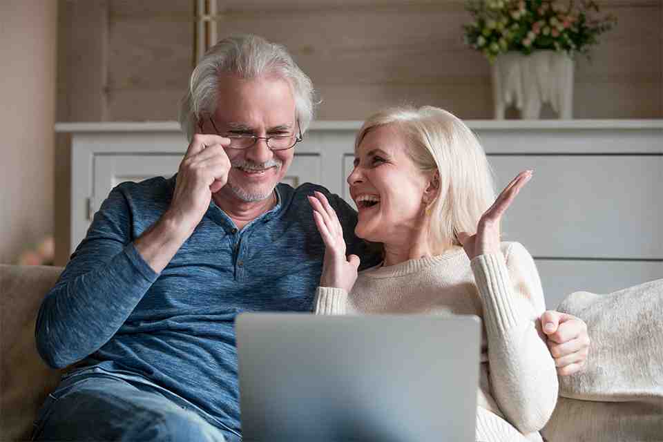 © fizkes - stock.adobe.com Zwei Pensionisten sitzen auf einer Couch mit einem Laptop