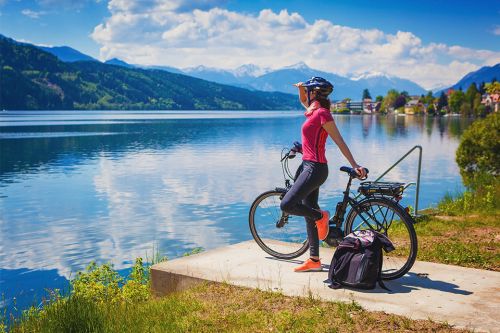Frau mit E-Bike genießt den Blick über den See