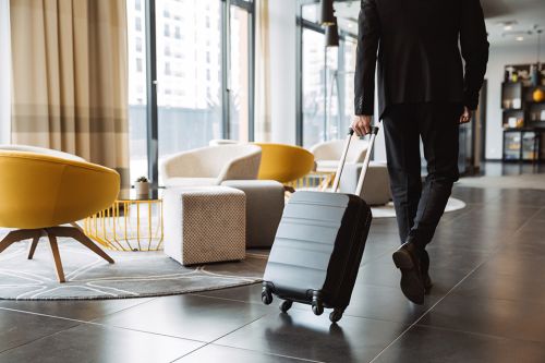 Mann zieht Koffer in Hotellobby